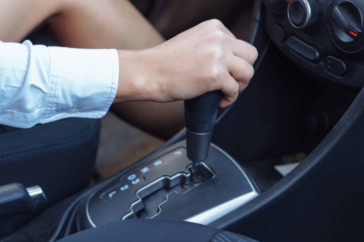 Womans hand holding a gear lever. Automatic transmission.