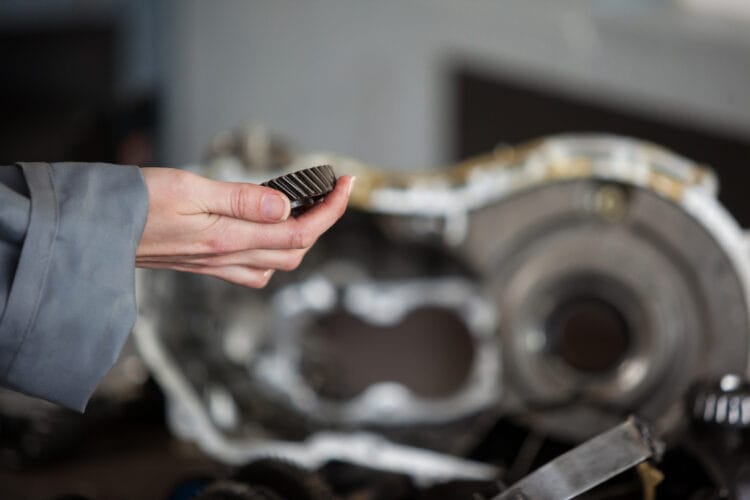 Mechanic holding bevel gear at the repair garage