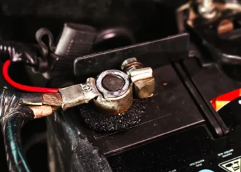 Close-up de terminal de bateria automotiva com sinais de oxidação e corrosão, destacando a importância da manutenção preventiva e da limpeza correta dos cabos para garantir bom funcionamento elétrico do veículo.