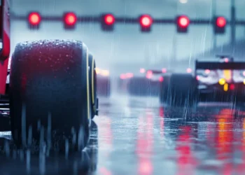 Carros de Fórmula 1 sob chuva leve nos boxes de Interlagos, com refletores vermelhos acesos e atmosfera intensa antes da corrida Sprint, simbolizando o treino livre da F1 Brasil.