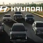 Imagem com seis carros da Hyundai em uma estrada, com o logotipo da marca em destaque acima dos veículos, representando a nova política de manutenção e reparos autorizados implementada pela montadora.