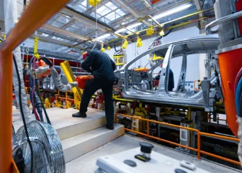 Linha de montagem de veículos em fábrica brasileira, mostrando trabalhadores atuando na produção de carros sustentáveis, ilustrando o impacto do programa Mover e da isenção do IPI zero.