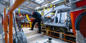 Linha de montagem de veículos em fábrica brasileira, mostrando trabalhadores atuando na produção de carros sustentáveis, ilustrando o impacto do programa Mover e da isenção do IPI zero.