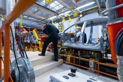 Linha de montagem de ve&iacute;culos em f&aacute;brica brasileira, mostrando trabalhadores atuando na produ&ccedil;&atilde;o de carros sustent&aacute;veis, ilustrando o impacto do programa Mover e da isen&ccedil;&atilde;o do IPI zero.