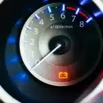 Painel de carro com luz de advertência da bateria acesa em vermelho, indicando possível falha no sistema de carga ou no alternador. A imagem representa a importância de agir rapidamente ao identificar esse alerta no veículo.