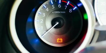 Painel de carro com luz de advertência da bateria acesa em vermelho, indicando possível falha no sistema de carga ou no alternador. A imagem representa a importância de agir rapidamente ao identificar esse alerta no veículo.