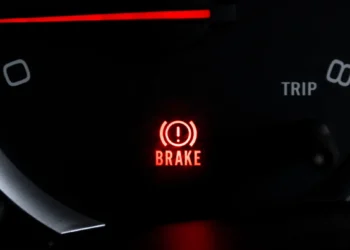 "Luz de freio acesa no painel do carro indicando alerta no sistema de frenagem"