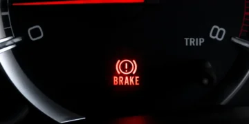 "Luz de freio acesa no painel do carro indicando alerta no sistema de frenagem"