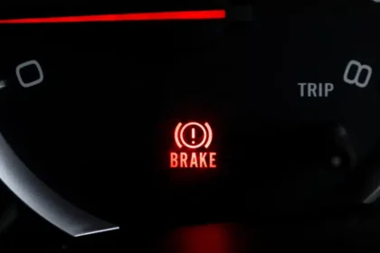 "Luz de freio acesa no painel do carro indicando alerta no sistema de frenagem"