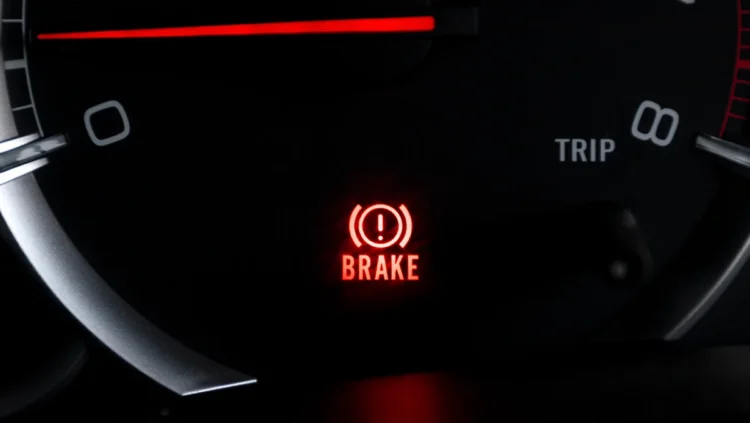 "Luz de freio acesa no painel do carro indicando alerta no sistema de frenagem"