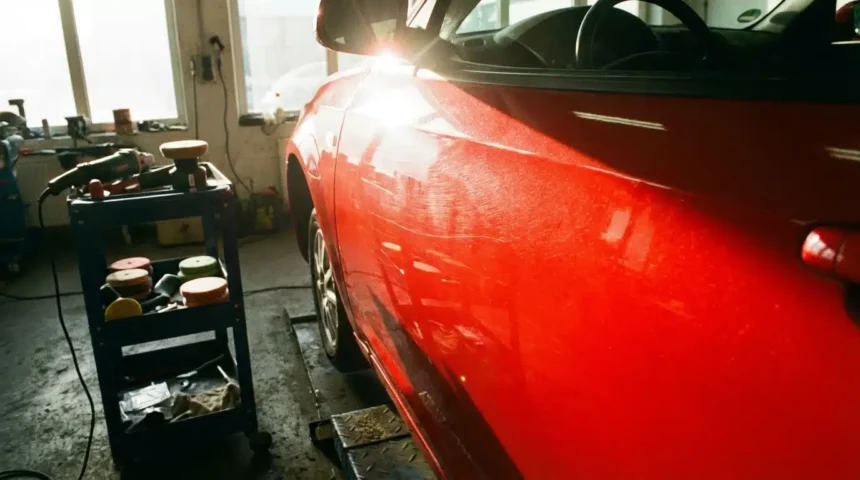 Carro com foco na porta, destacando riscos leves e microrelevo sob o sol, ferramentas de polimento ao lado na oficina