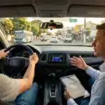 Instrutor autônomo orienta jovem motorista em carro moderno, refletindo as novas regras do Contran e o fim das aulas obrigatórias.