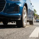 Imagem hiper-realista de pneu com pressão baixa em carro urbano brasileiro, destacando erro pneus pode aumentar impacto no consumo