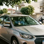 Interior de carro compacto brasileiro com ar condicionado gasta muita gasolina, vista através do vidro sob sombra de árvore na cidade brasileira