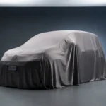 Imagem de alta qualidade de um carro coberto por lona em estúdio, destacando o lançamento de Stellantis investe R$ 32, com destaque para o Fiat Panda 2025.