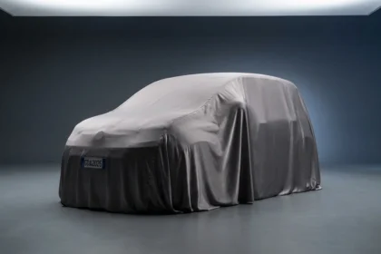 Imagem de alta qualidade de um carro coberto por lona em est&uacute;dio, destacando o lan&ccedil;amento de Stellantis investe R$ 32, com destaque para o Fiat Panda 2025.