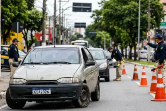 Multas Graves 2026: Cena de blitz com policiais federais e carro com pneus carecas e vidros danificados, destaque para multas graves 2026