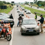 Fiscalização policial na rodovia brasileira durante operação rodovida, com agentes, veículos e motociclistas em atenção máxima
