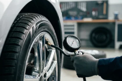 Roda dianteira esquerda de carro com calibragem pneu viagem, medidor de press&atilde;o, oficina limpa e ambiente preparado para viagem