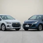 Cena frontal de Onix ou HB20 em cores prata e azul escuro em alta resolução, destacando linhas aerodinâmicas e LED, ideal para comparação.