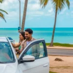 Pessoa sorrindo ao alugar carro em Maceió com o mar ao fundo