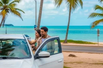 Pessoa sorrindo ao alugar carro em Maceió com o mar ao fundo