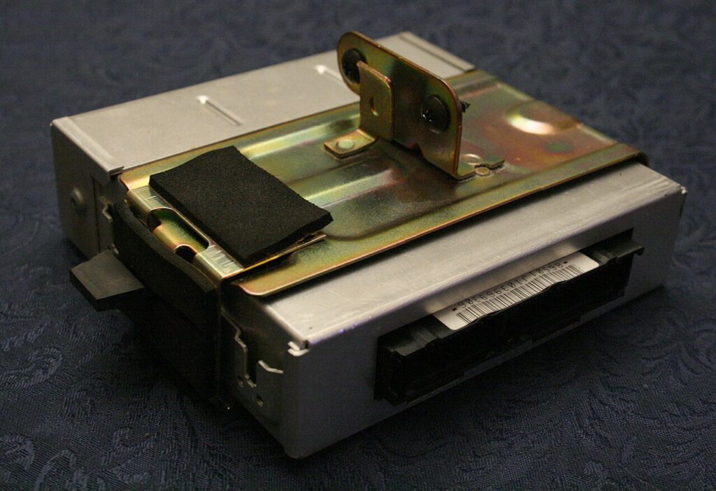 Módulo eletrônico de um carro antigo: uma caixa de metal com o conector do chicote. O módulo do câmbio (TCM) é parecido, e é nele que ficam o software e os valores adaptados.