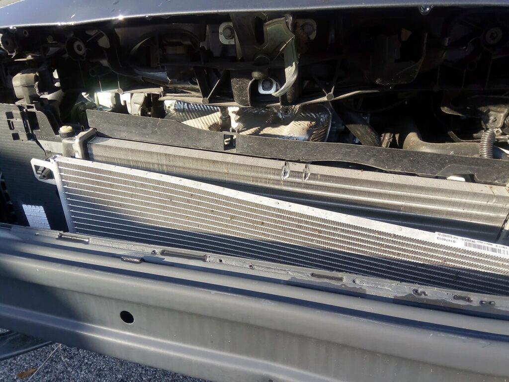 Frente de um carro sem o para-choque: o condensador do ar-condicionado fica na frente do radiador do motor.