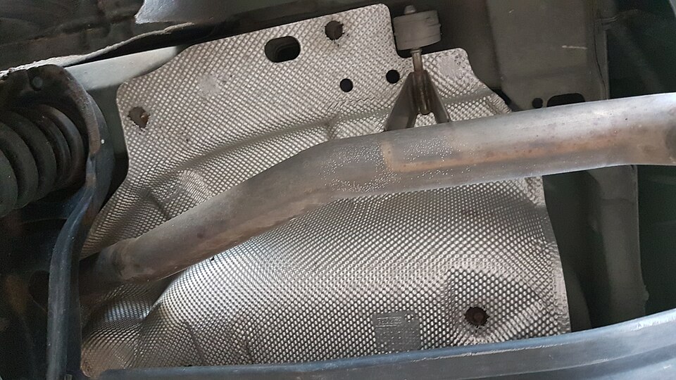 Protetor de calor de alumínio solto na parte traseira do escapamento: quando a fixação cede, a chapa começa a bater e fazer barulho de lata.