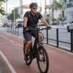 Ciclista de capacete numa bicicleta elétrica em ciclovia urbana, tema do projeto que fixa idade mínima de 15 anos