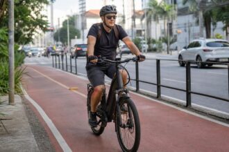 Ciclista de capacete numa bicicleta elétrica em ciclovia urbana, tema do projeto que fixa idade mínima de 15 anos