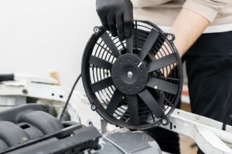 Ventoinha elétrica sendo instalada no cofre do motor, peça-chave da pressão no arrefecimento