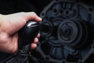 Motorista trocando a marcha na alavanca do câmbio automático