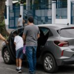 Família chega de carro para votar numa escola, cena de carona para votar no 2º turno