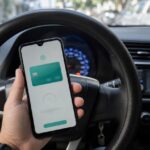Consulta ipva ms 2026: motorista faz a consulta IPVA MS no celular dentro do carro estacionado