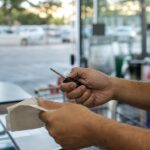 Motorista com a chave do carro e o cupom fiscal no caixa do supermercado, de olho no desconto no IPVA 2027 do RS