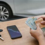 Cédulas de real e chave de carro: dólar hoje passa de R$ 5,60 e preocupa quem pensa em comprar carro