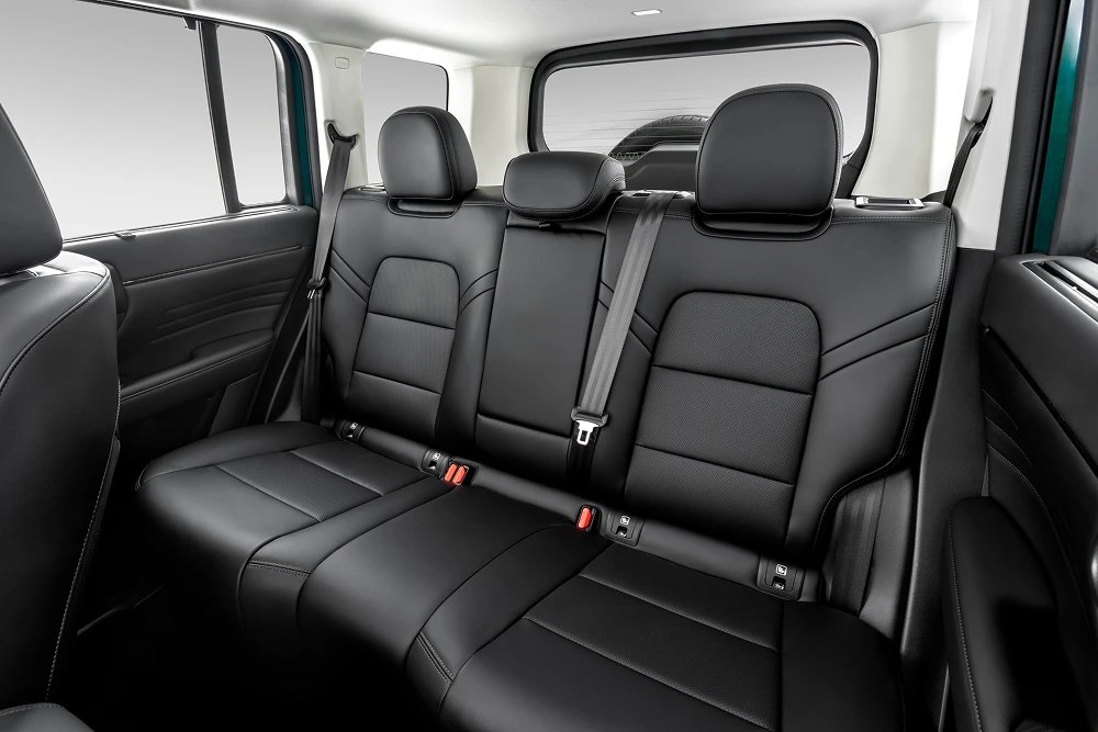 GWM Haval H7: sUV híbrido moderno em destaque no showroom envidraçado de uma concessionária com cliente e vendedor ao fundo de costas. — foto 6