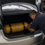 Cilindro de GNV no porta-malas de um carro durante a instalação de GNV numa oficina