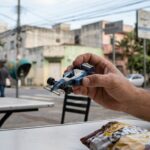 Miniaturas de Fórmula 1: close-up em miniatura de carro de corrida sobre mesa em ambiente urbano.