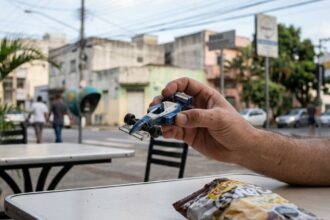 Miniaturas de Fórmula 1: close-up em miniatura de carro de corrida sobre mesa em ambiente urbano.