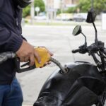 Moto consumindo muita gasolina o que pode ser: motociclista abastece moto urbana com gasolina em posto de combustível