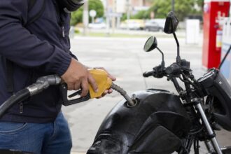 Moto consumindo muita gasolina o que pode ser: motociclista abastece moto urbana com gasolina em posto de combustível