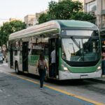 Ônibus elétrico num ponto de avenida brasileira, tema dos debates de transporte no Pavilhão Brasil COP31
