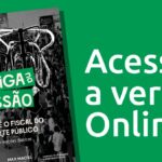 Placas de trânsito: operário de costas com luvas fixando parafuso em suporte de placa de trânsito amarela no acostamento de rodovia brasileira.