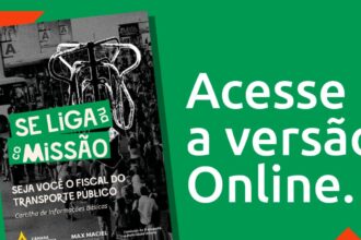 Placas de trânsito: operário de costas com luvas fixando parafuso em suporte de placa de trânsito amarela no acostamento de rodovia brasileira.