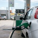 Bico da bomba de combustível em abastecimento de veículo durante fiscalização de preço abusivo de combustíveis.