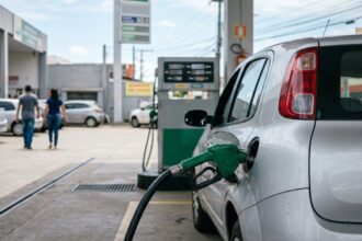 Bico da bomba de combustível em abastecimento de veículo durante fiscalização de preço abusivo de combustíveis.