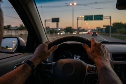 Visão do motorista ao volante trafegando em rodovia com alerta para romeiros na Via Dutra.