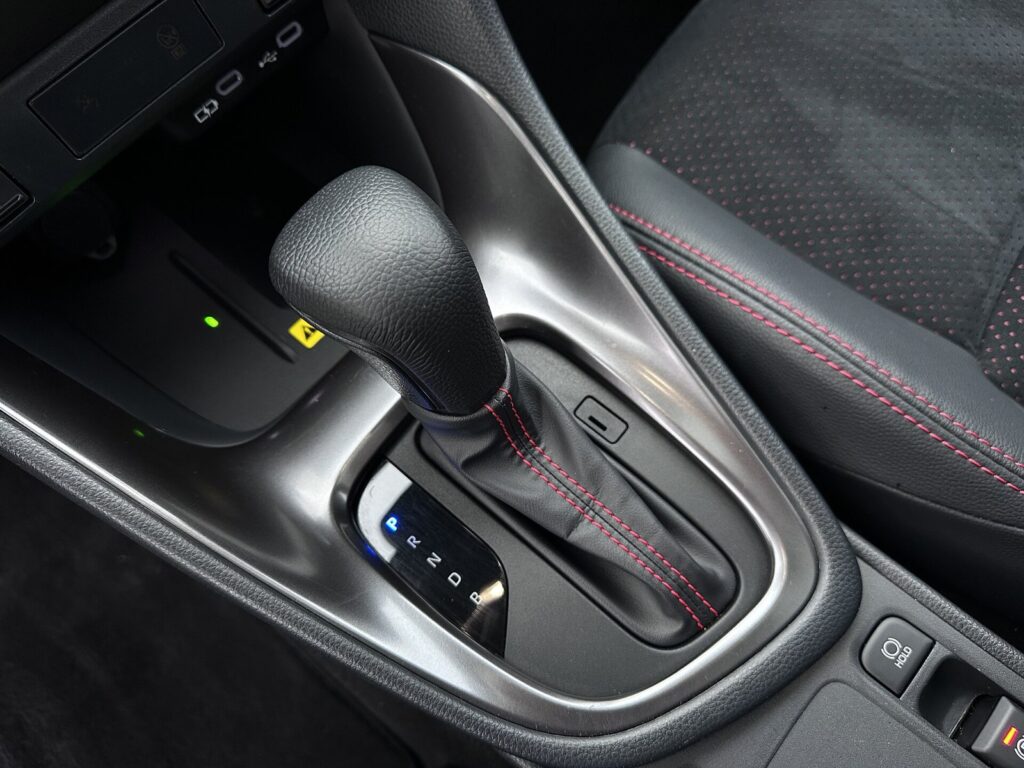 Shift Lock: alavanca de câmbio automático com botão de trava no console central de um veículo.